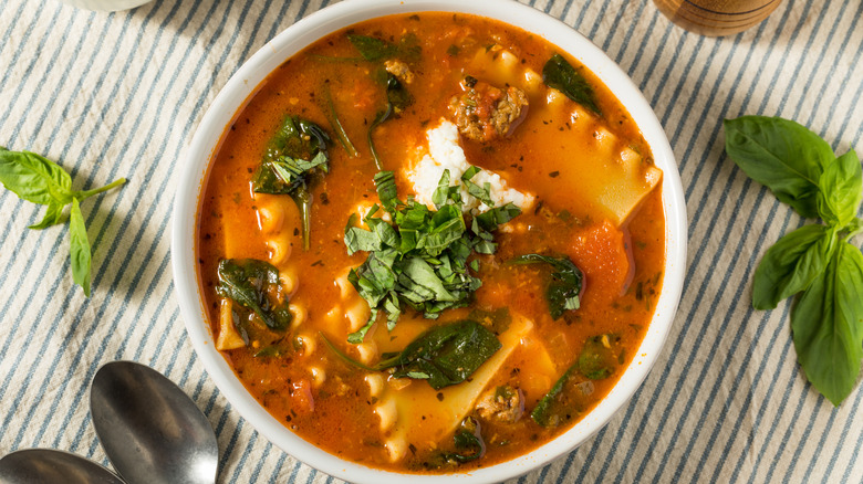 Bowl of lasagna soup garnished with chopped fresh basil