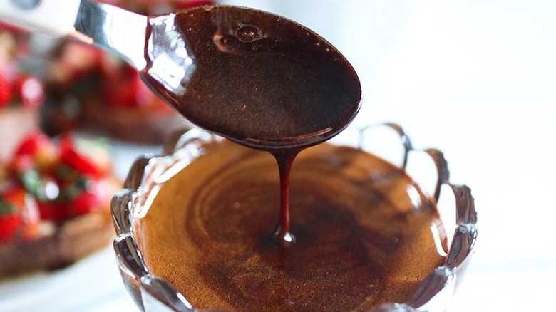 Spooning balsamic glaze from small glass bowl