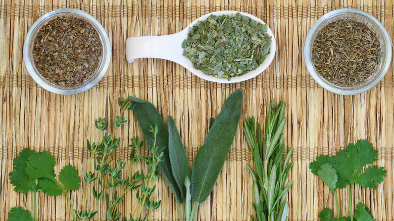 fresh and dried herbs, shown in an overhead view on a bamboo mat