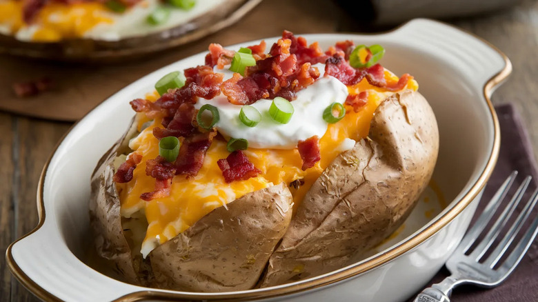 Baked potato in dish with fork