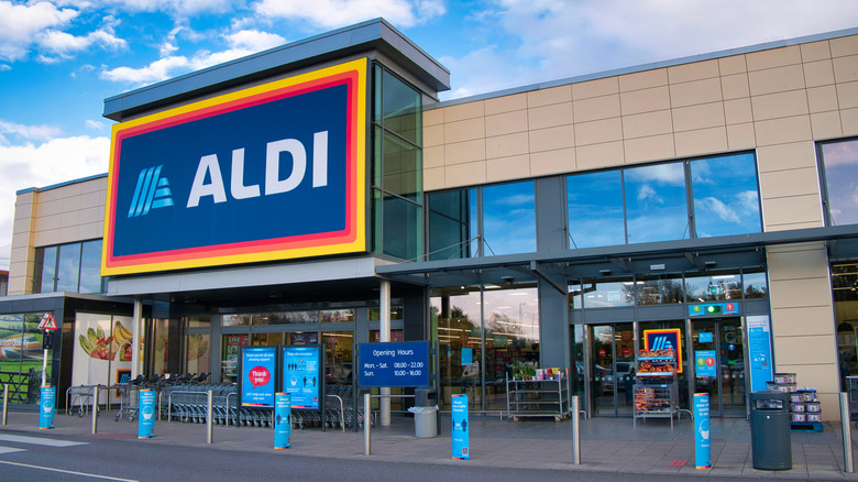 Front of Aldi store in UK with road out front against blue sky with clouds