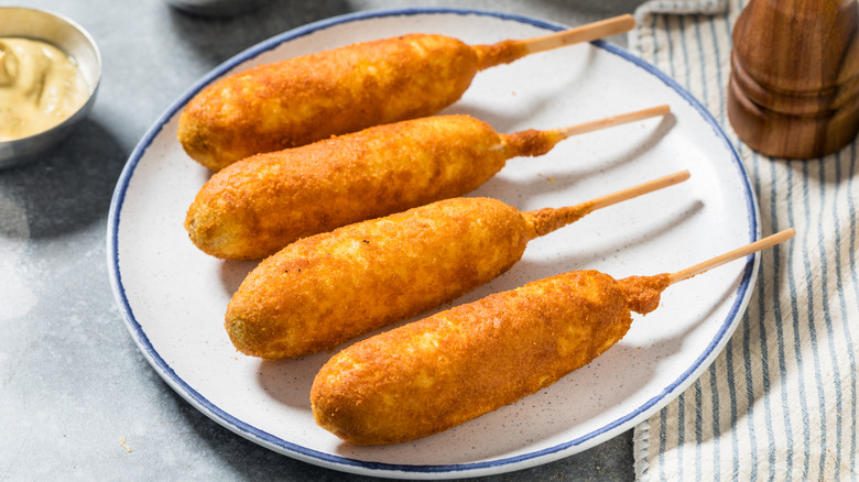 Four corn dogs on plate
