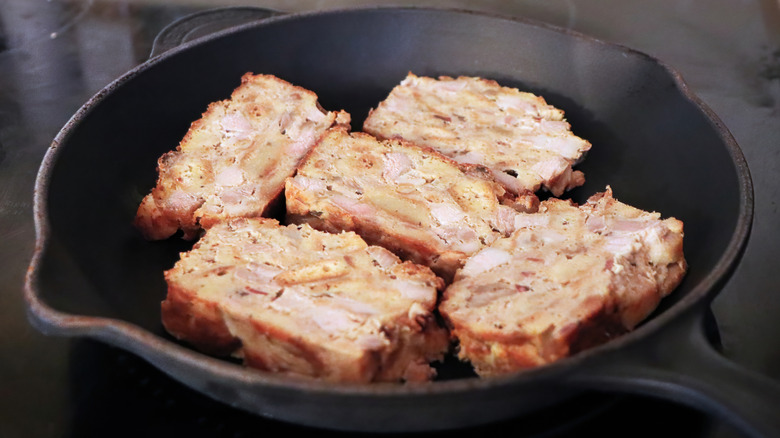 Slice of scrapple frying in pan