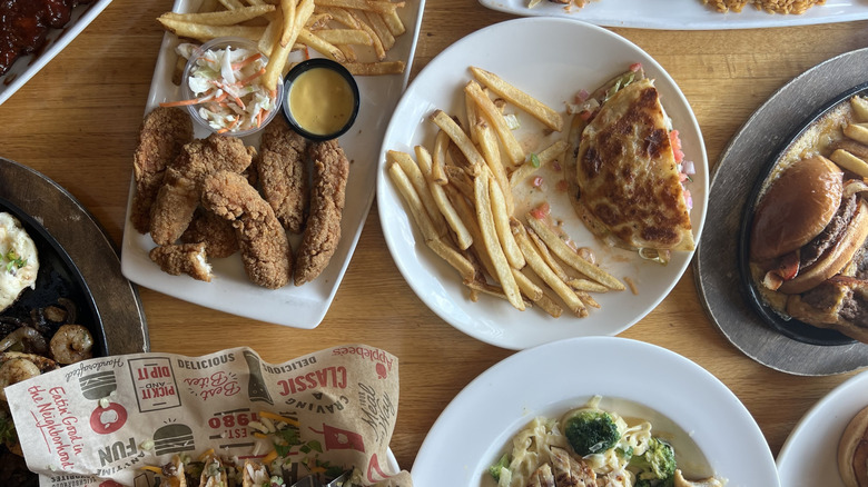 10 different Applebee's entrees laid out on table.
