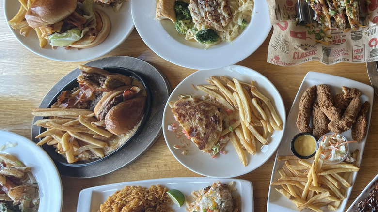 Applebee's entrees spread out on table.