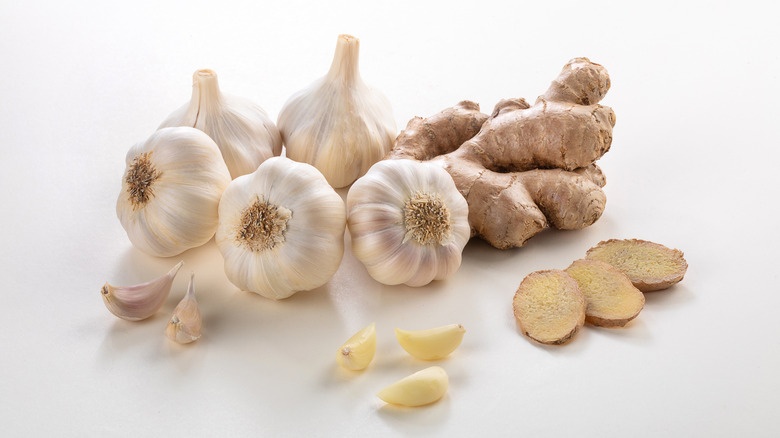 Garlic bulbs and fresh ginger root on white background