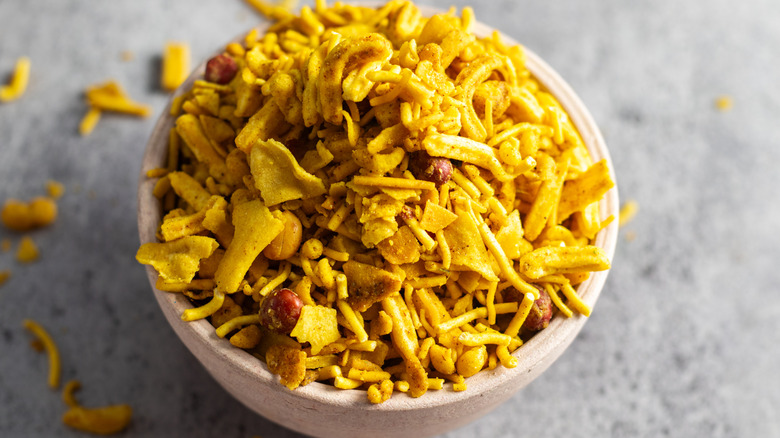 Bombay mix piled high in a bowl and spilling onto the countertop