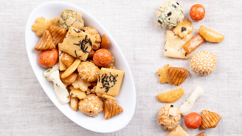Assorted rice crackers in a bowl and on a tablecloth