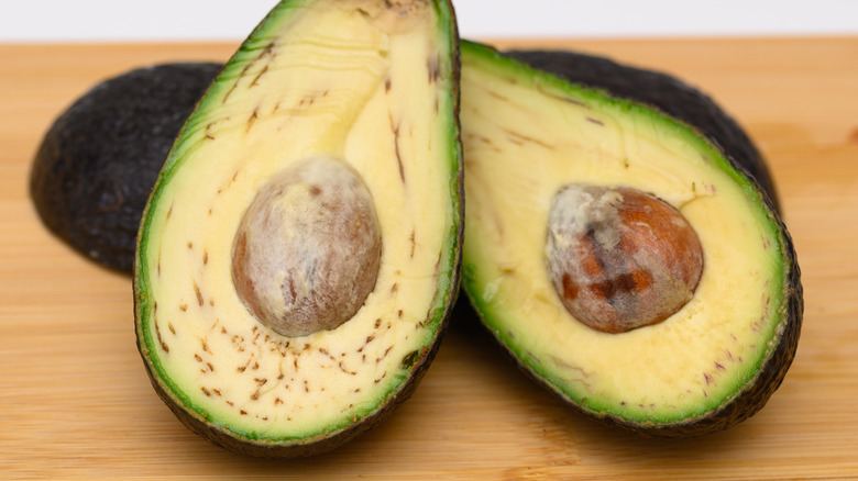 Avocado sliced open with brown strings called vascular bundles