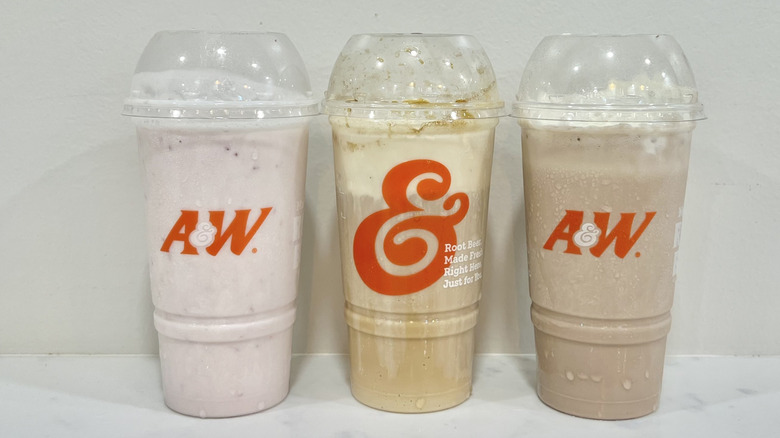 Three A&W ice cream drinks in to-go cups.