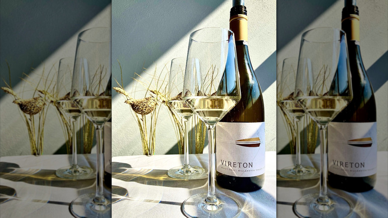 Bottle of Vireton Pinot Gris with wine glasses on a white table