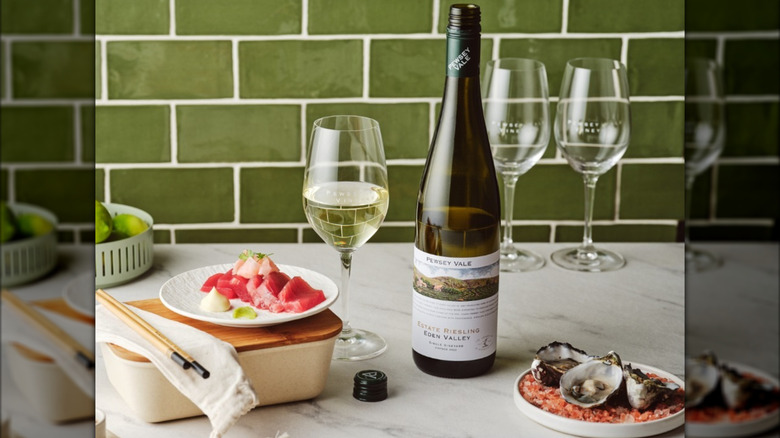 Bottle of Estate Riesling 2025 with oysters and wine glasses on a marble countertop