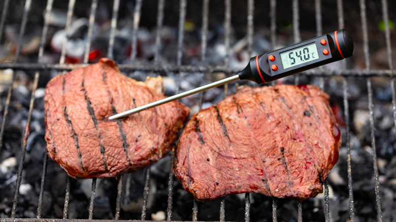 meat thermometer in steak on a grill