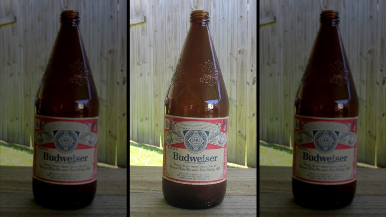 Mirrored image of vintage budweiser bottle outside on table in front of fence