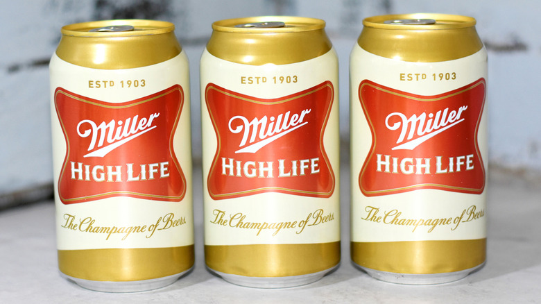 Three cans of Miller High Life on counter