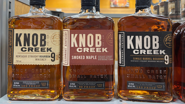 three bottles of knob creek bourbon on a shelf