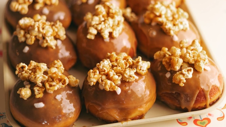 Group of popcorn-topped donuts on a tray