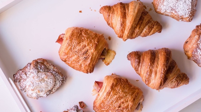 Assortment of pastries and croissants on white tray