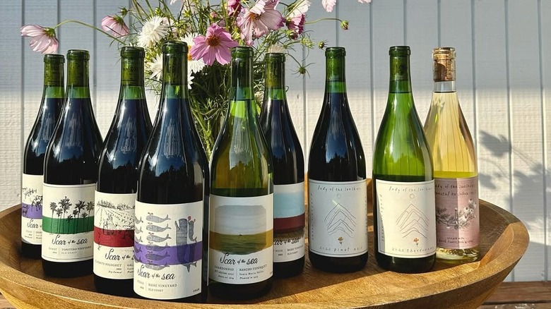 assorted wine bottles with flowers on table