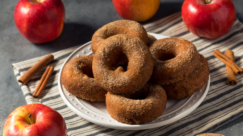 Apple cider donuts stacked on white plate
