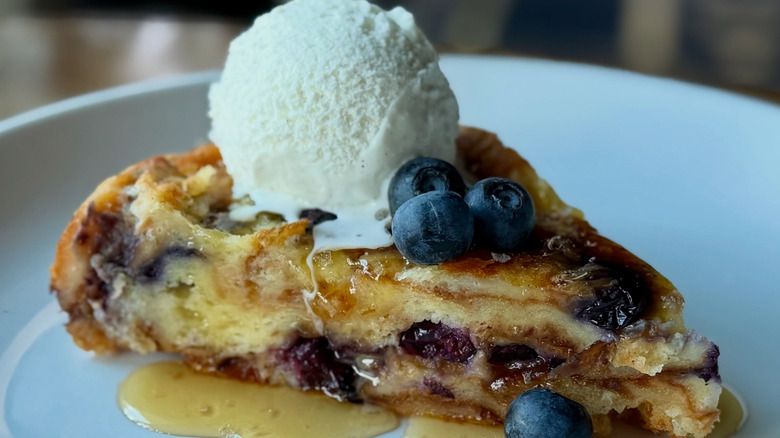 slice of blueberry bread pudding topped with vanilla ice cream