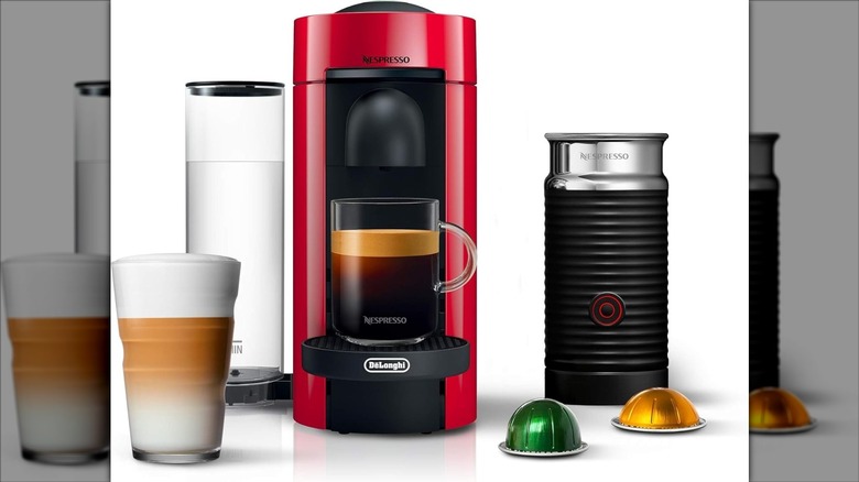 Red De'Longhi Nespresso Vertuo Plus deluxe coffee machine with milk frother, pods, and drinks