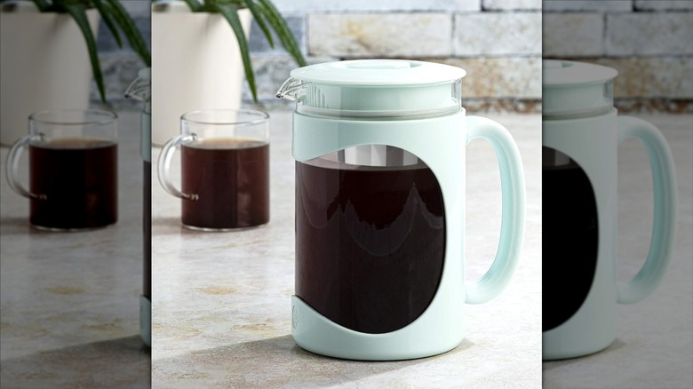 Primula Burke deluxe cold brew iced coffee maker on countertop with cup of coffee