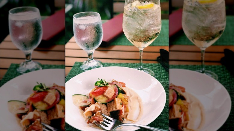 Panzanella served on a white plate at Magnolias at the Mill in Purcellville with drinks on the side