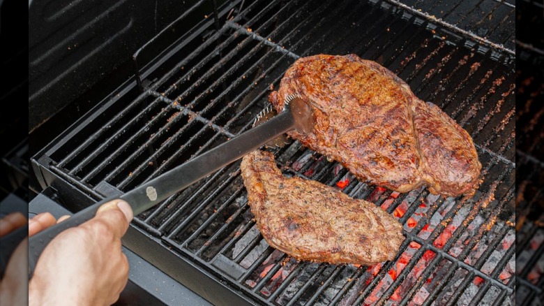 Grille Perfect 24-inch Grill Tongs being used to pick up a steak