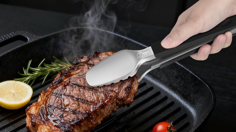 Hotec grill tongs being used to pick up a steak
