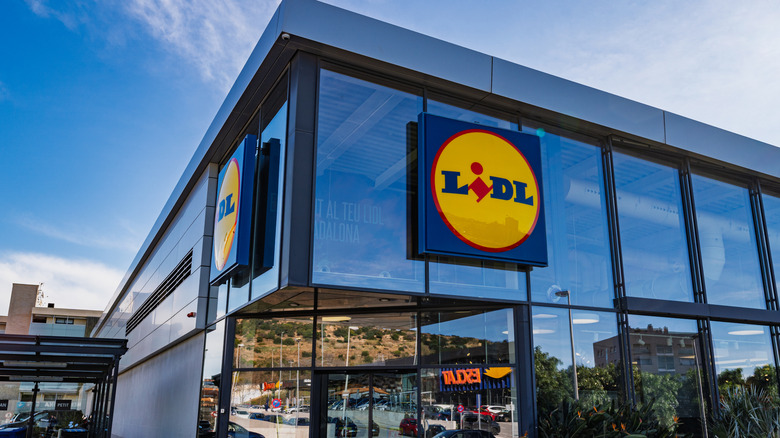 Glass Lidl store against cloudy blue sky