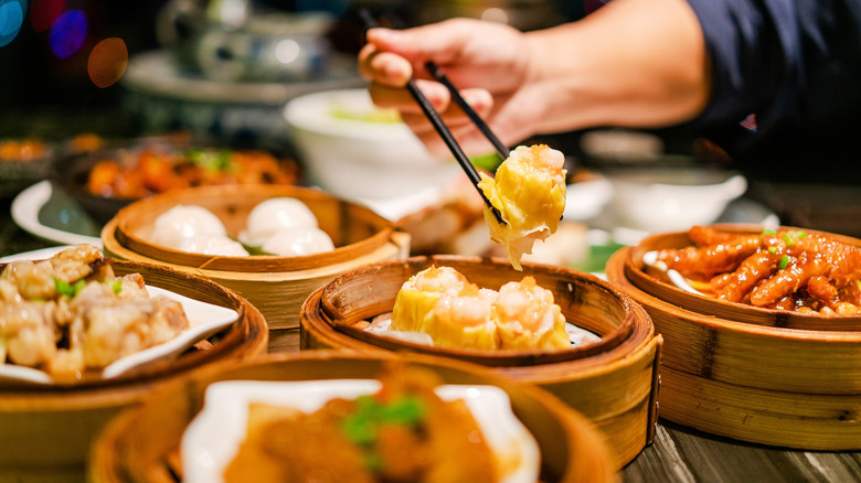 Hands picking up Chinese food with chopsticks