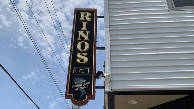 Corner sign advertising Rino's Place in Boston