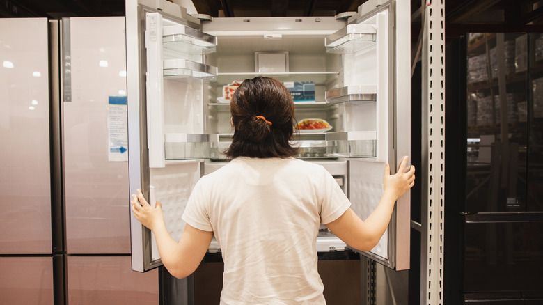 Someone opening a fridge while shopping
