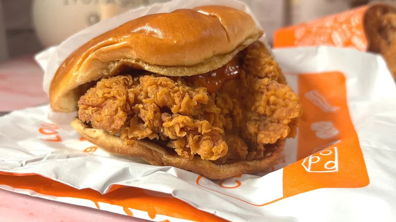 Popeyes x Hot Ones Smokin' Rojo Sandwich on top of paper wrapping