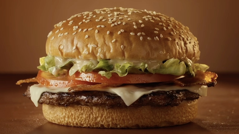 Close-up image of a burger with lettuce, bacon, and tomatoes