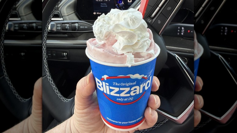 Hand holding a Dairy Queen blizzard with whipped cream