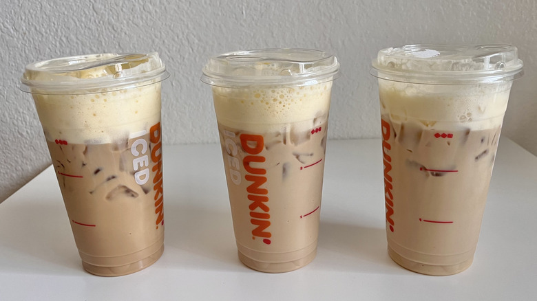 Three Dunkin' cups with iced coffee
