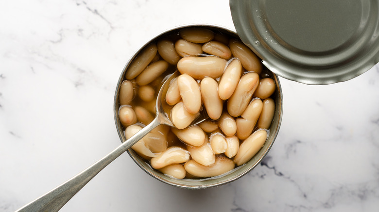 Opened can of white beans with spoon