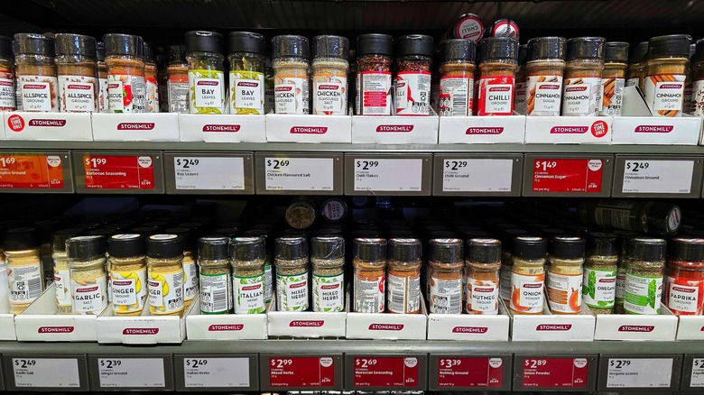 Jars of dried herbs and spices on grocery store shelves