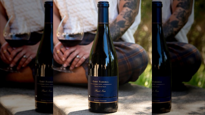 bottle of red wine with person in the background