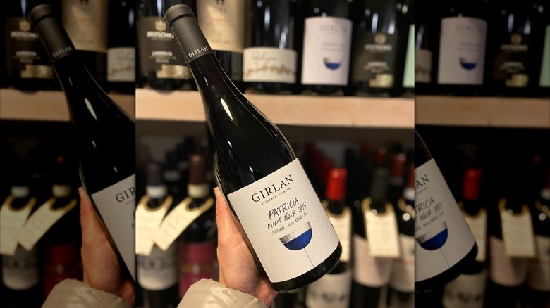 hand holding bottle of wine in shop