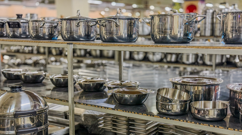 Shelves displaying commercial kitchen equipment in a restaurant supply store