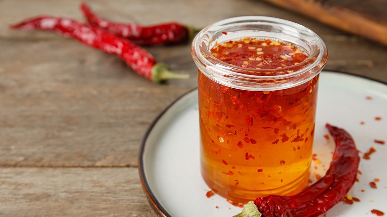 Jar of honey with chili pepper flakes and dried chilis