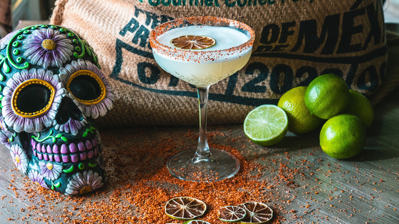 Margarita with tajin, decorated skull and limes