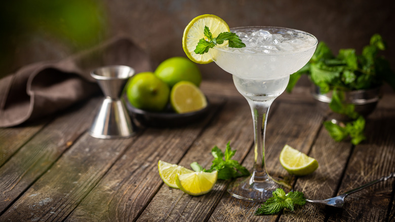 A margarita garnished with lime and mint