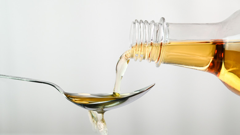 Pouring apple cider vinegar onto spoon