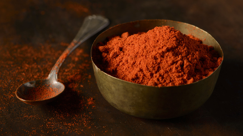 Chili powder in bowl next to spoon