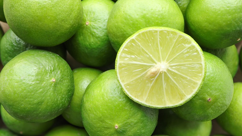 Pile of fresh limes with one cut in half