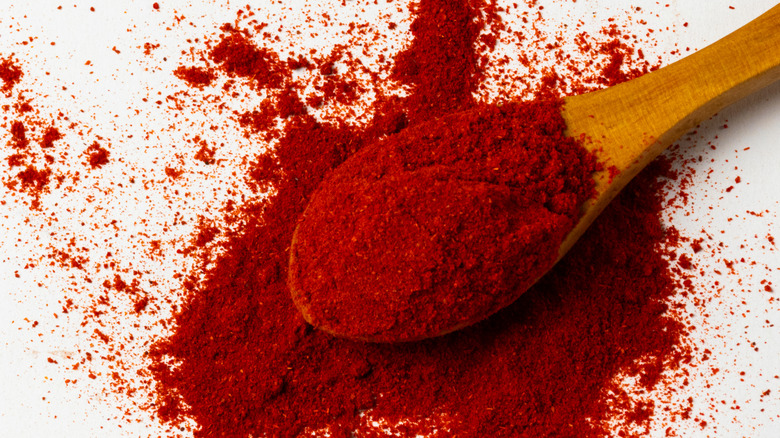 Smoked paprika spilling from wooden spoon